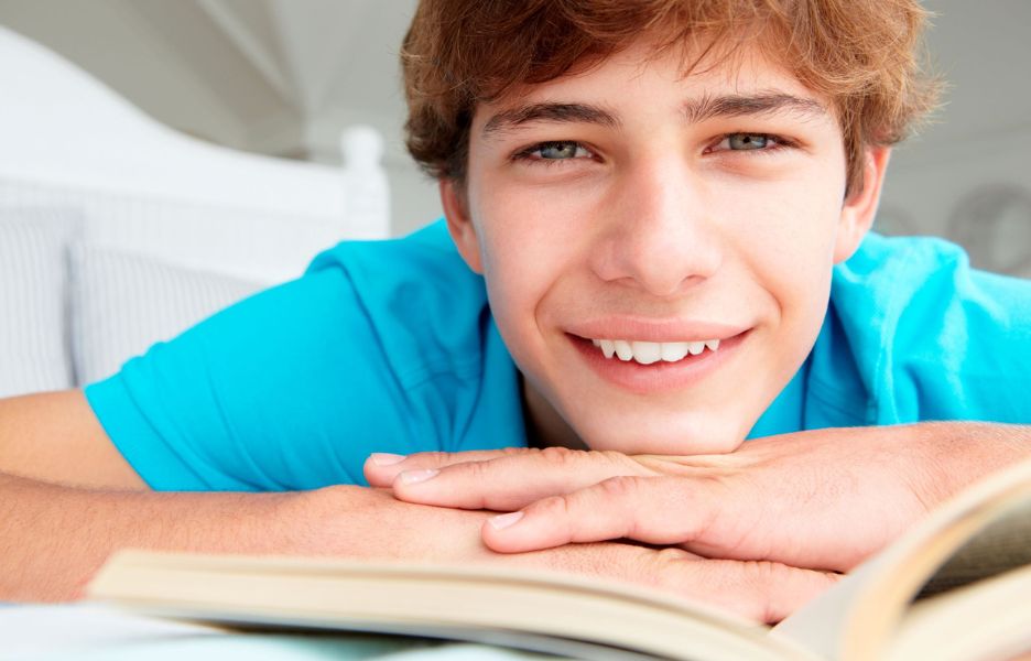 Smiling teenage boy with a book